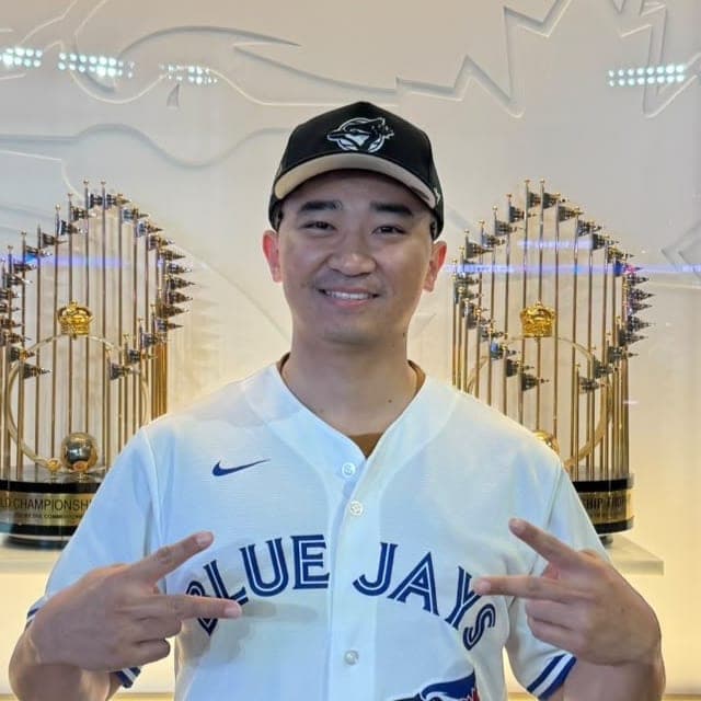 Suyu smiling in a Blue Jays cap and jersey